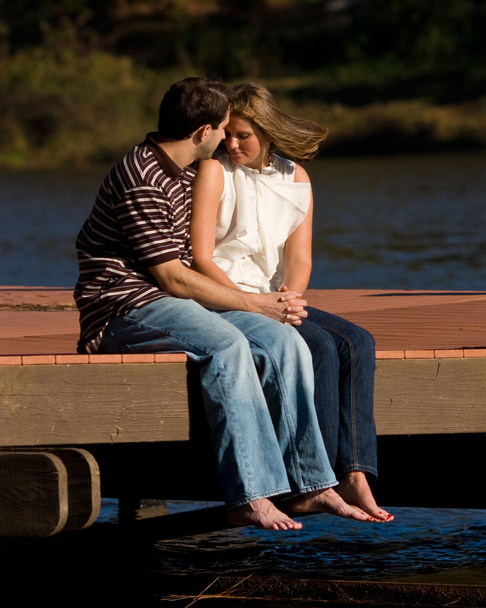 Молода пара закоханих босоніж сидіти на док над озером - Фото, зображення