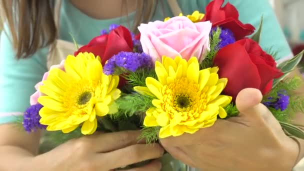 Close up shot of florist woman arranging beautiful flowers in a glass vase - Footage, Video