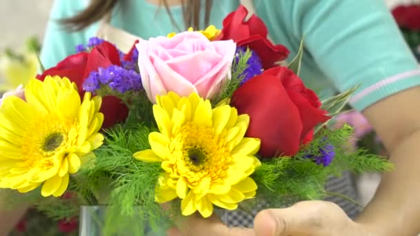 Közelről lövés virágárus nő megszervezése szép virágok egy üvegvázában - Felvétel, videó