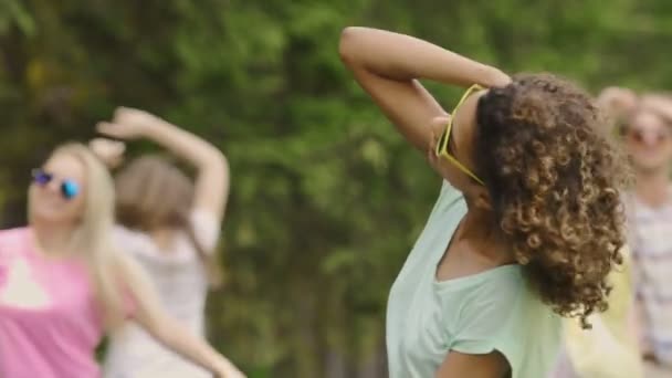 Young female singer dancing in music clip, backup dancers partying on background - Footage, Video