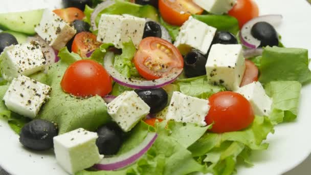 Griekse salade met verse groenten, feta en zwarte olijven draaien - Video