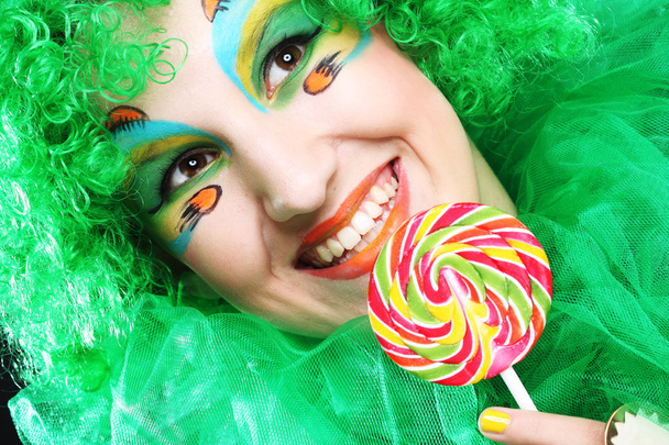 Girl with with creative make-up holds lollipop - Фото, изображение