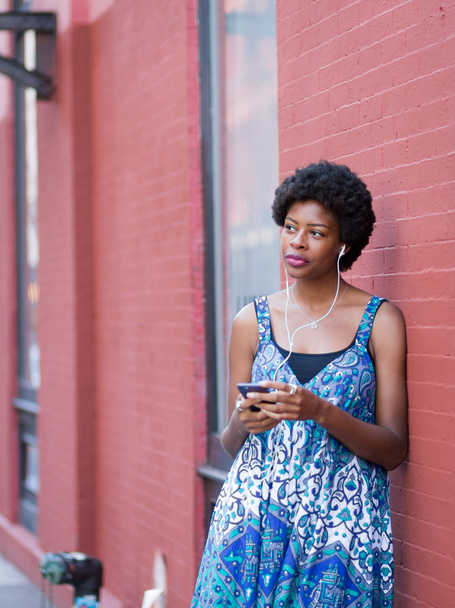 Joven modelo afroamericano escuchando música y readint texto
 - Foto, Imagen