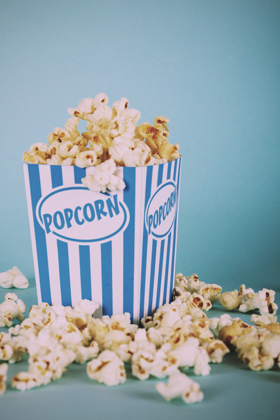 Popcorn bucket against a blue background Vintage Retro Filter. - Φωτογραφία, εικόνα