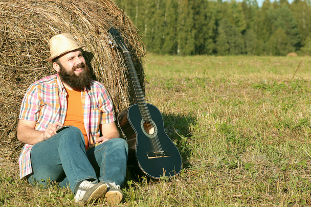 Mann mit Gitarre und Bier in der Natur - Foto, Bild