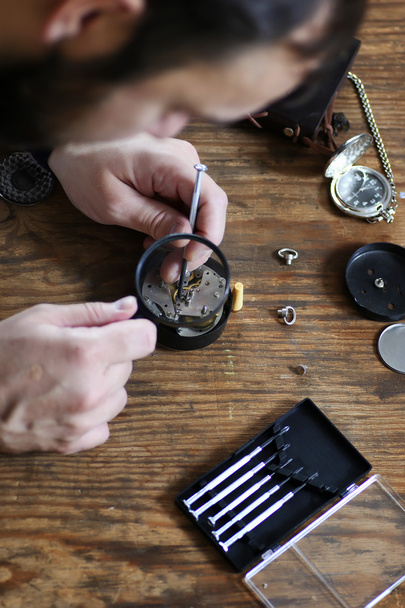 black and white photo of man repairing watch clock  - Foto, imagen