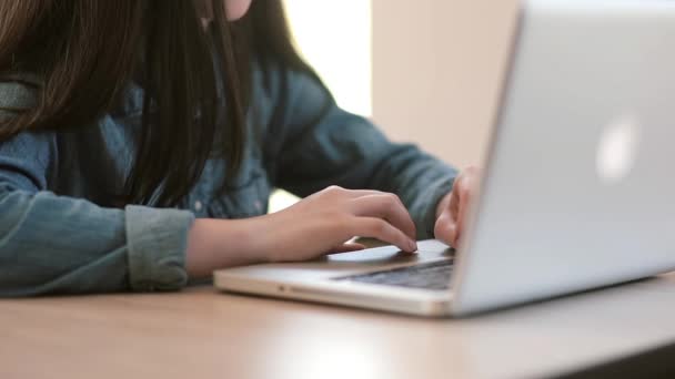 Teenage girls using a laptop sitting at table at home - Video, Çekim