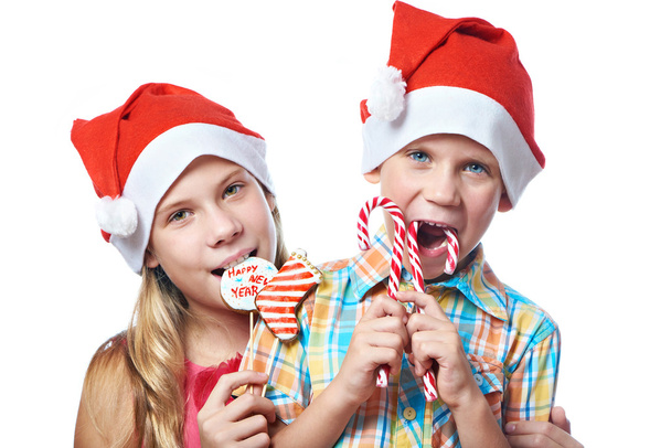 Children in red caps with Christmas sweets isolated - Foto, imagen