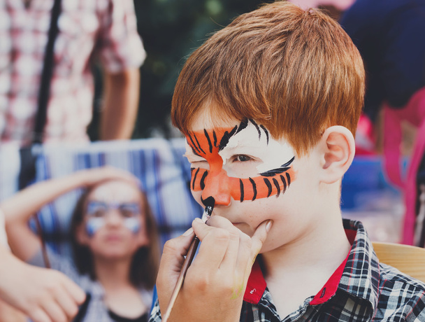 Bambino ragazzo faccia pittura, rendendo tigre occhi processo
 - Foto, immagini