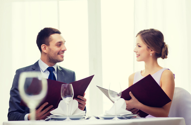 smiling couple with menus at restaurant - Fotoğraf, Görsel