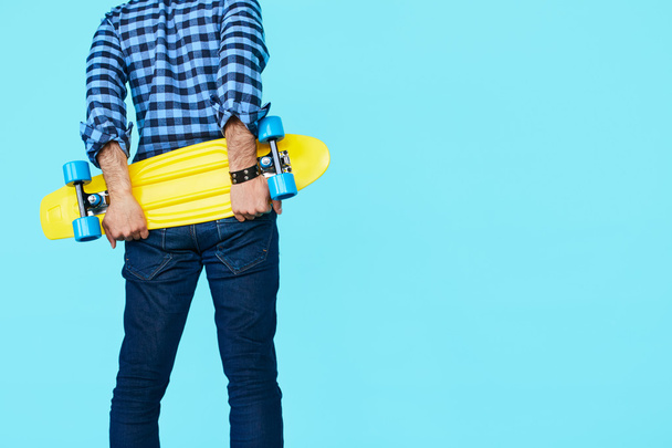 Hipster holding his skateboard - 写真・画像