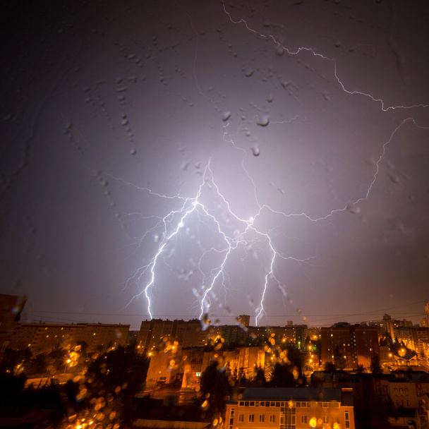 Bulutlar ve gök gürültüsü Lightning'ler ve şehir üzerinde fırtına. Damla ile cam - Fotoğraf, Görsel