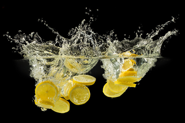 Group of fresh fruits falling in water with splash on black back - 写真・画像