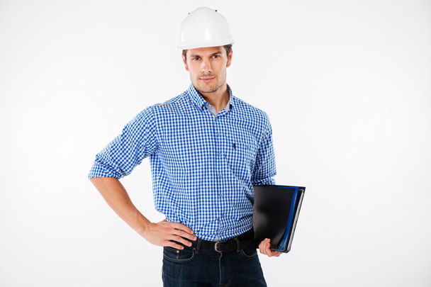 Handsome young man building engineer in helmet with folder - Foto, Imagem