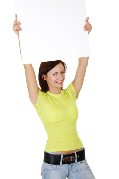 Happy smiling young woman showing blank signboard - Фото, изображение