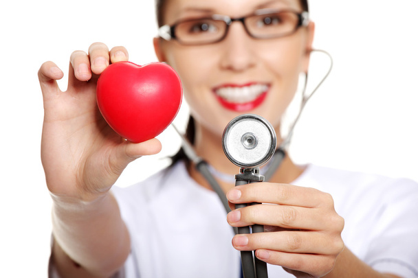 Female doctor holding red heart in hand - Φωτογραφία, εικόνα