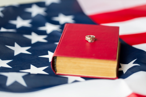 close up of american flag, wedding rings and bible - Foto, imagen