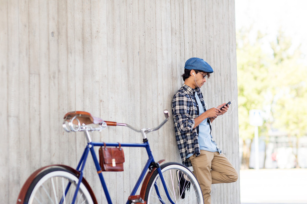 man with smartphone, earphones and bicycle - Foto, Imagen