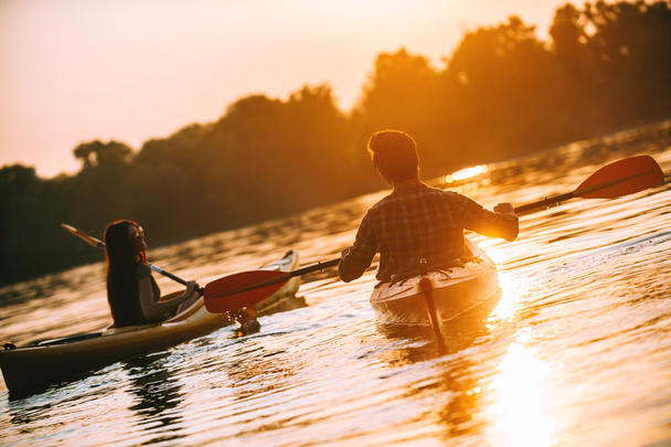 beautiful couple kayaking on river together - Fotó, kép