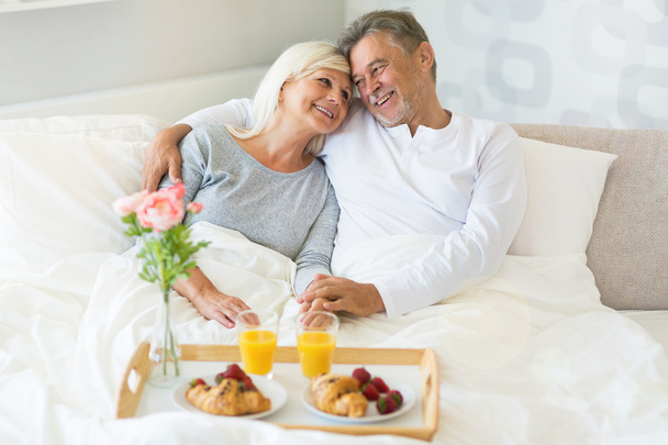 Senior couple enjoying breakfast in bed - Photo, Image