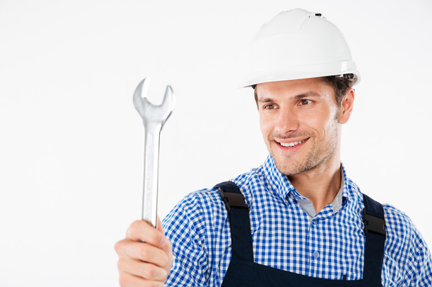 Smiling male handsome builder holding wrench - Foto, Imagen