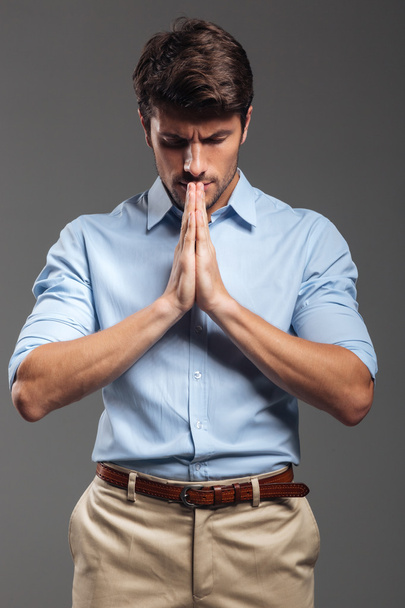 Portrait of a handsome businessman praying with eyes closed - Foto, afbeelding