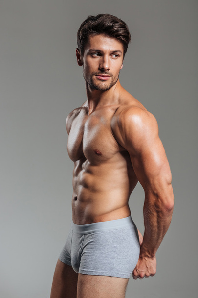 Sexy young brunette man showing muscles - Fotó, kép