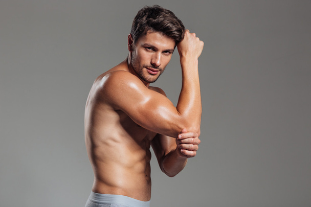 Sexy young brunette man showing muscles - 写真・画像