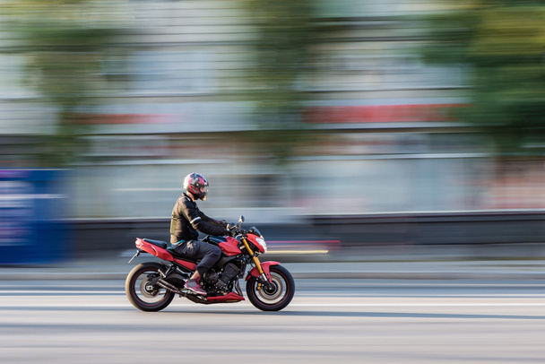 Motociclista em movimento rápido na motocicleta com fundo desfocado
 - Foto, Imagem