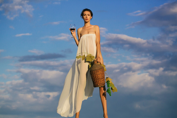 hübsches Mädchen mit Weinflasche über dem Himmel - Foto, Bild