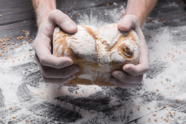 Αρτοποιείο έννοια φόντο. Τα χέρια κρατούν φραντζόλα ψωμί - Φωτογραφία, εικόνα