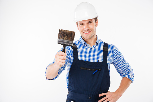 Smiling male painter holding paint brush - Foto, afbeelding