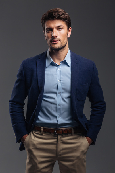 Handsome young confident man standing with hands in pockets - Fotoğraf, Görsel