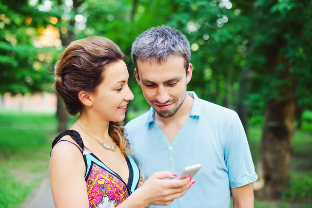 Young couple on a walk with their smart phones  - Foto, Bild