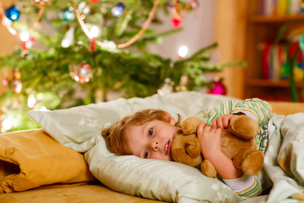 Petit enfant blond mignon dormant sous l'arbre de Noël
 - Photo, image