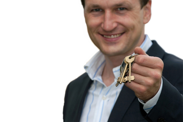 Real estate agent holds out the front door key of a new home - Фото, зображення