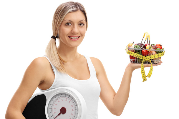 Vrouw met een winkelwagentje en een gewicht-schaal - Foto, afbeelding