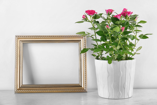 Vase with roses and photo frame on table - Foto, Imagem