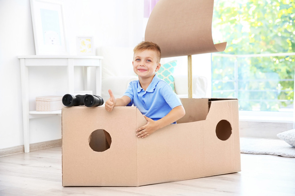 Little boy playing with cardboard ship indoors - Photo, Image