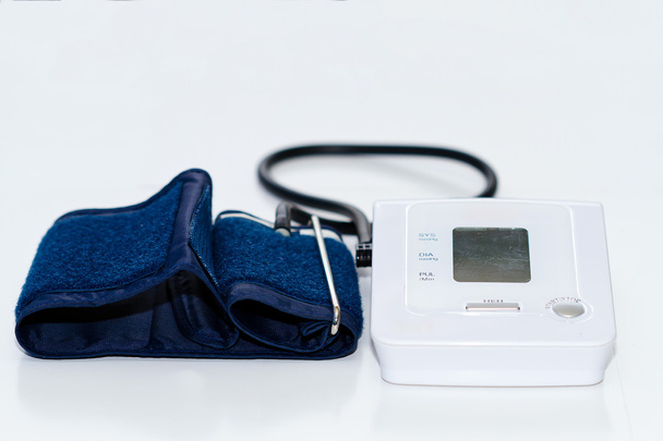 Medidor digital automático de monitorización de la presión arterial sobre fondo blanco  - Foto, imagen