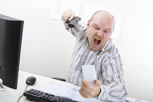 Angry Businessman Aiming Gun On Mobile Phone At Desk - Photo, Image