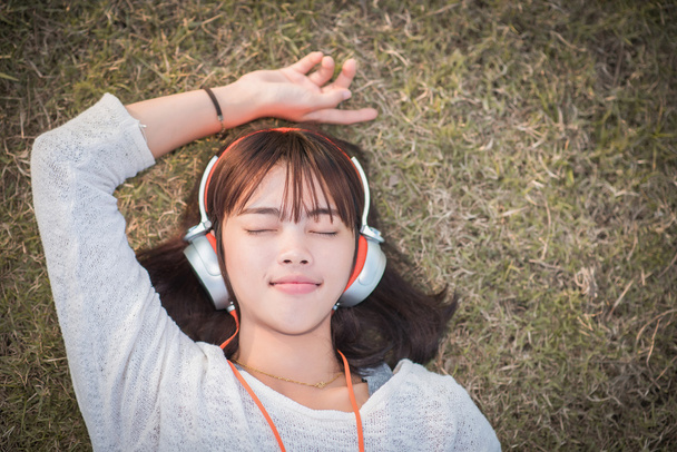 Relaxed woman listening to the music with headphones lying on th - Foto, immagini
