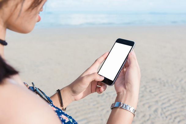 woman's hand using smart phone at beach.  - Zdjęcie, obraz
