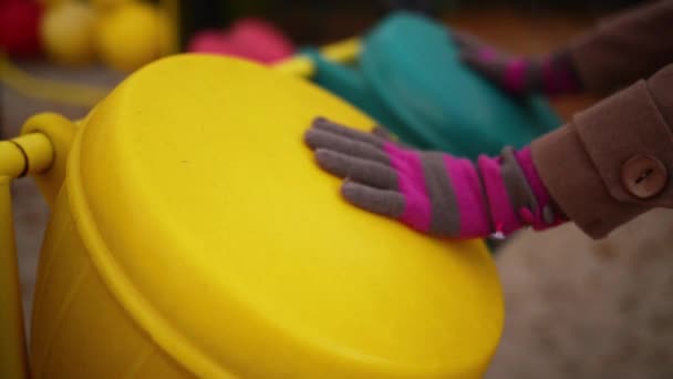 Vrouw in handschoenen kloppen op een speelgoed-trommel op de speelplaats in de herfst stadspark. - Video