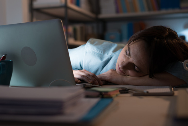 exhausted woman sleeping near laptop - Foto, immagini