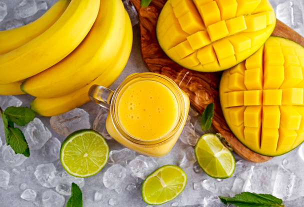 Healthy Yellow Banana Mango Smoothie with slices of Lime, mint and ice - Фото, зображення