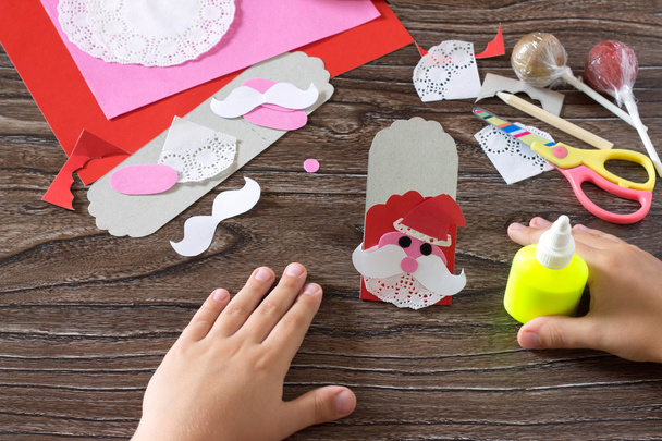 El niño crear un embalaje de saludo para dulces Santa Claus en p
 - Foto, Imagen
