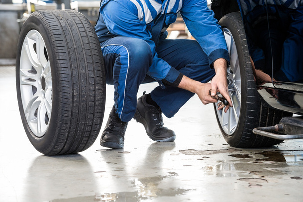 Male mechanic changing car tire - Photo, Image