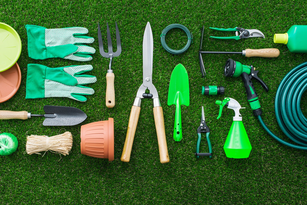 Set of gardening tools on the lush grass in the garden, flat lay - Zdjęcie, obraz