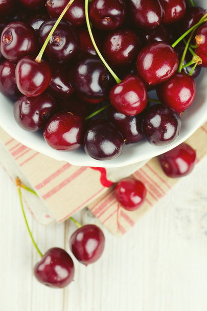 cherries in a bowl on wooden background - Φωτογραφία, εικόνα